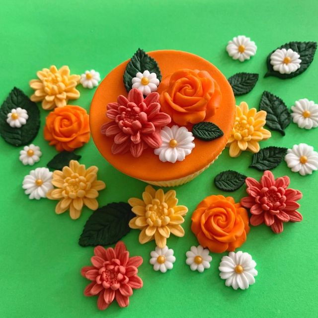 Orange sugar dahlias, roses and daisies with dark green leaves