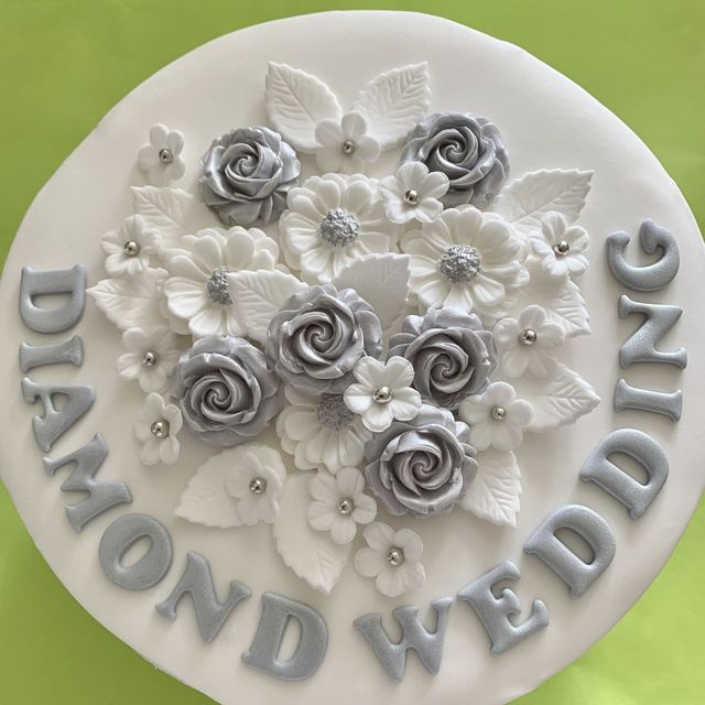 Pale silver sugar roses and white flowers on a Diamond Wedding cake